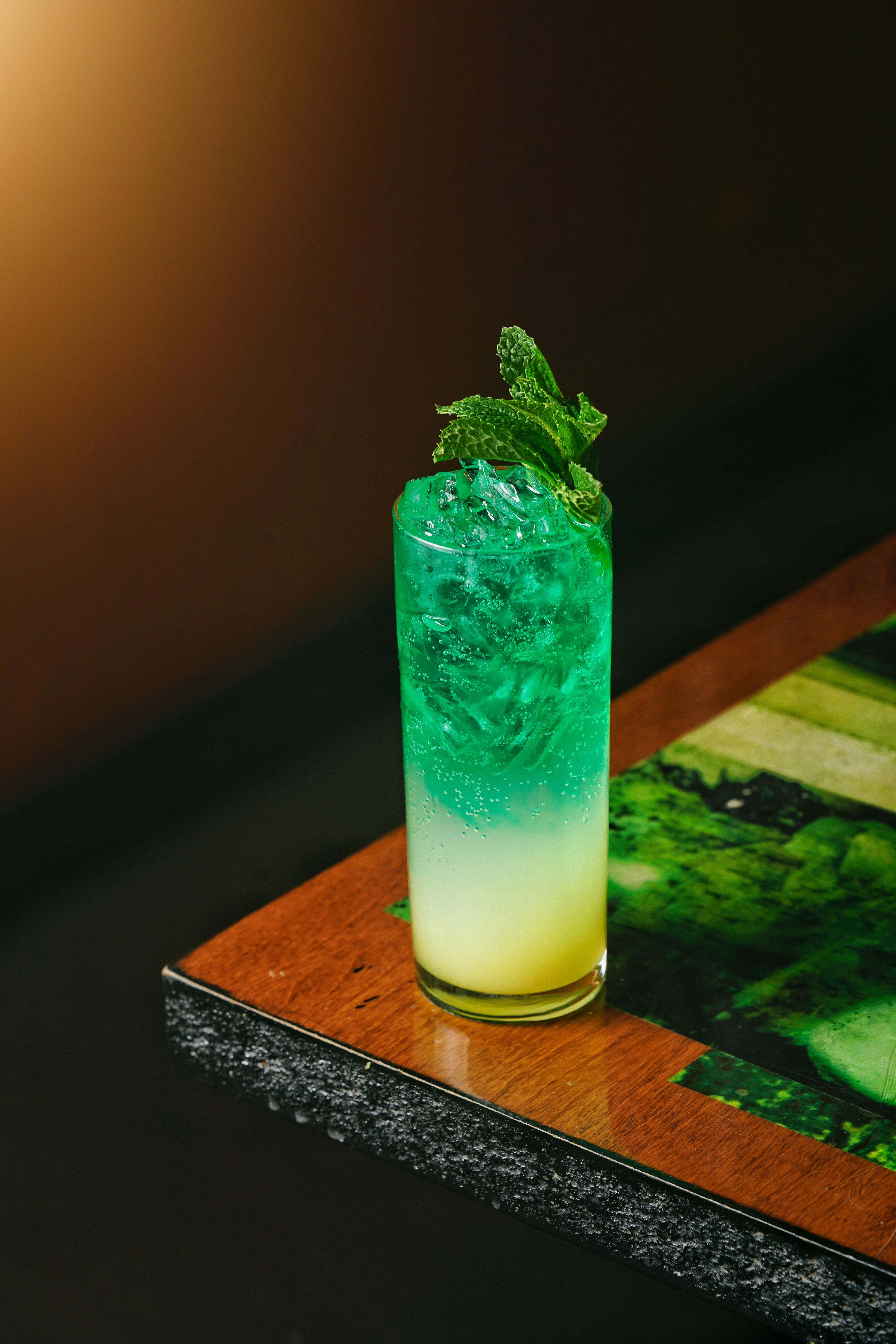 a green and yellow drink sitting on top of a wooden table